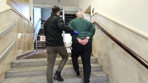 Nieumundurowany policjant prowadzący po schodach zatrzymanego