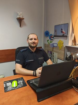 Policjant siedzący przy biurku