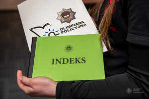 indeks oraz teczka Akdaemi Policyjnej trzymana w dłoni