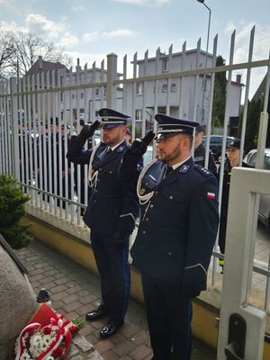 Dwóch policjantów oddających chołd przed pomnikiem
