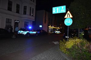 Policyjny radiowóz w nocy na ulicy miasta.