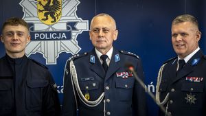 Dwóch policjantów w mundurach galowych oraz jeden w umundurowaniu służbowym stojących pprzy niebiekim policyjnym banerze