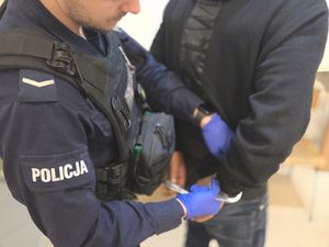 Policjant skuwający zatrzymanego w kajdani