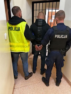 Policjanci prowadzący zatrzymanego.
