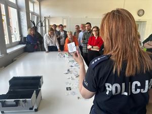 Zdjęcie ze spotkania profilaktycznego podczas którego policjanci prezętują zawartośc walizki edukacyjnej e wktórej znajdują się atrapy narkotykow