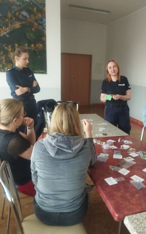 Zdjęcie ze spotkania profilaktycznego podczas którego policjanci prezętują zawartośc walizki edukacyjnej e wktórej znajdują się atrapy narkotykow