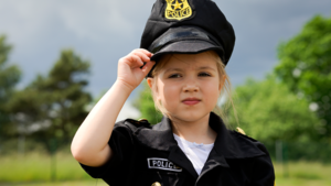 Dziecko w mundurze amerykanskiego policjanta pozujące do zdjęcia