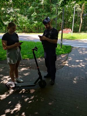Policjant kontrolujący kierujacego hulajnogą