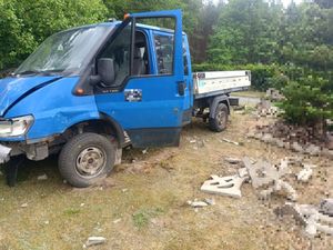 Niebieski samochód dostawczy po kolizji z ogrodzeniem