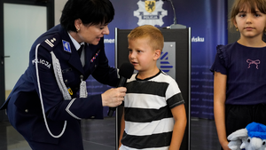 Policjantka podająca mikrofon dziecku