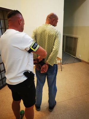 Policjant skuwający zatrzymanego mężczyznę