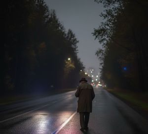 starszy mężczyzna idący nocą  jezdnią