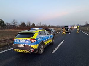 Policyjny radiowóz stojący na jezdni podczas zabezpieczenia miejsca zdarzenia