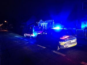 W nocy policyjny radiowuz stojący za innym pojazdem typu bus który na jezdni