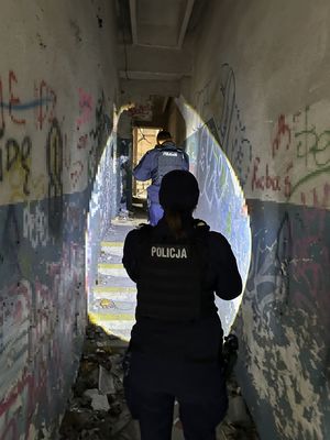 Policjanci idący korytarzem w pustostanie