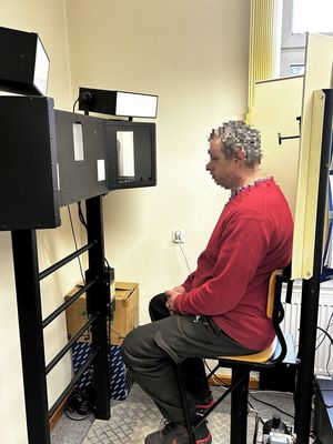 Mężczyzna siedzący na krześle przed policyjnym urządzeniem do robienia zdjęć