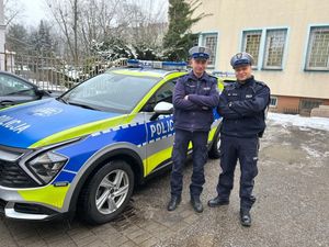 Policjanci stojący przy radiowozie