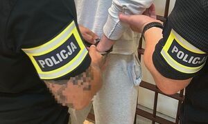 Policjanci prowadzący zatrzymanego.