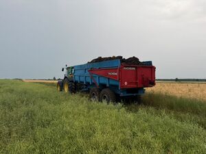 ciągnik z naczepą stojący na polu