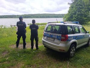 Policjanci podczas wspólnego patrolu ze stażą rybacką nad brzegiem jeziora