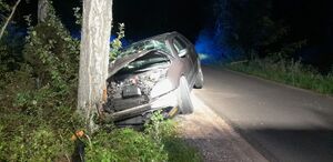rozbity pojazd stojący przy drzewie w nocy