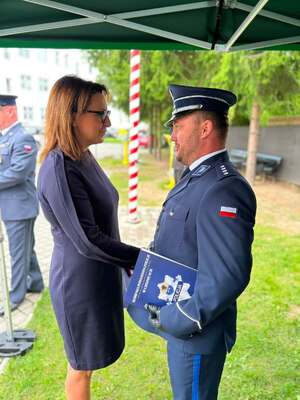 Policjant składający gratulacj e kobiecie w sukience