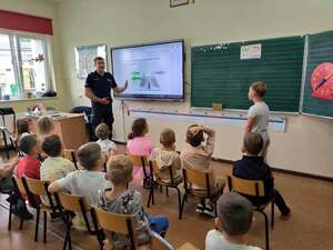 Policjant na spotkaniu z dzięcmi w sali lekcyjnej