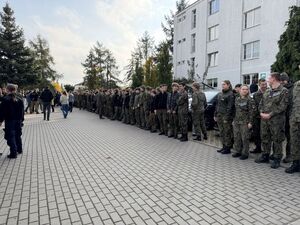 Uczniowie klasy mundurowej podczas próbnej ewakuacji szkoły stojący na parkingu w szeregach